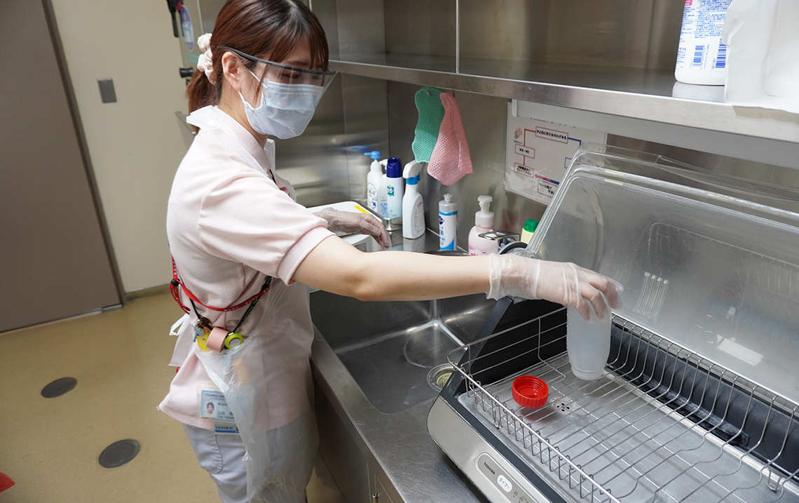 汚物室を清掃する山田さん